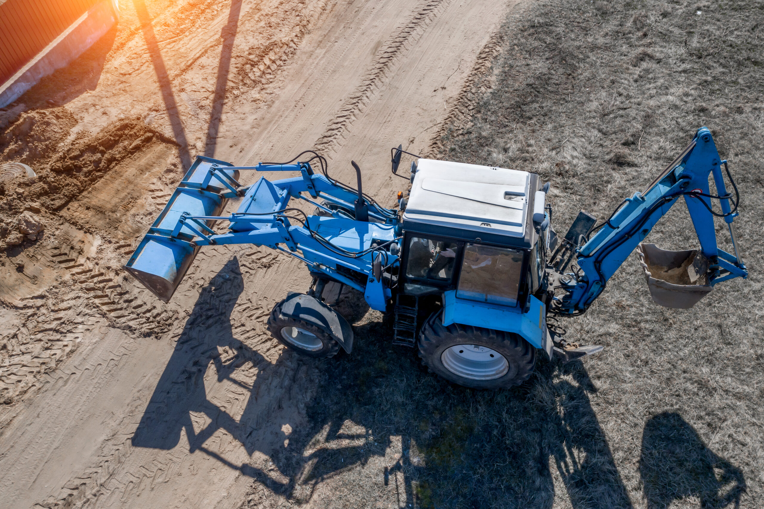 Grassy field with standing water near a brown fence line.