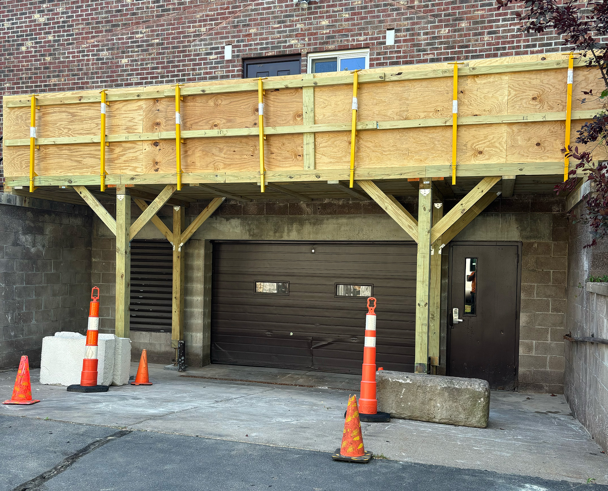 Yellow excavator parked on a snowy road by a forest.