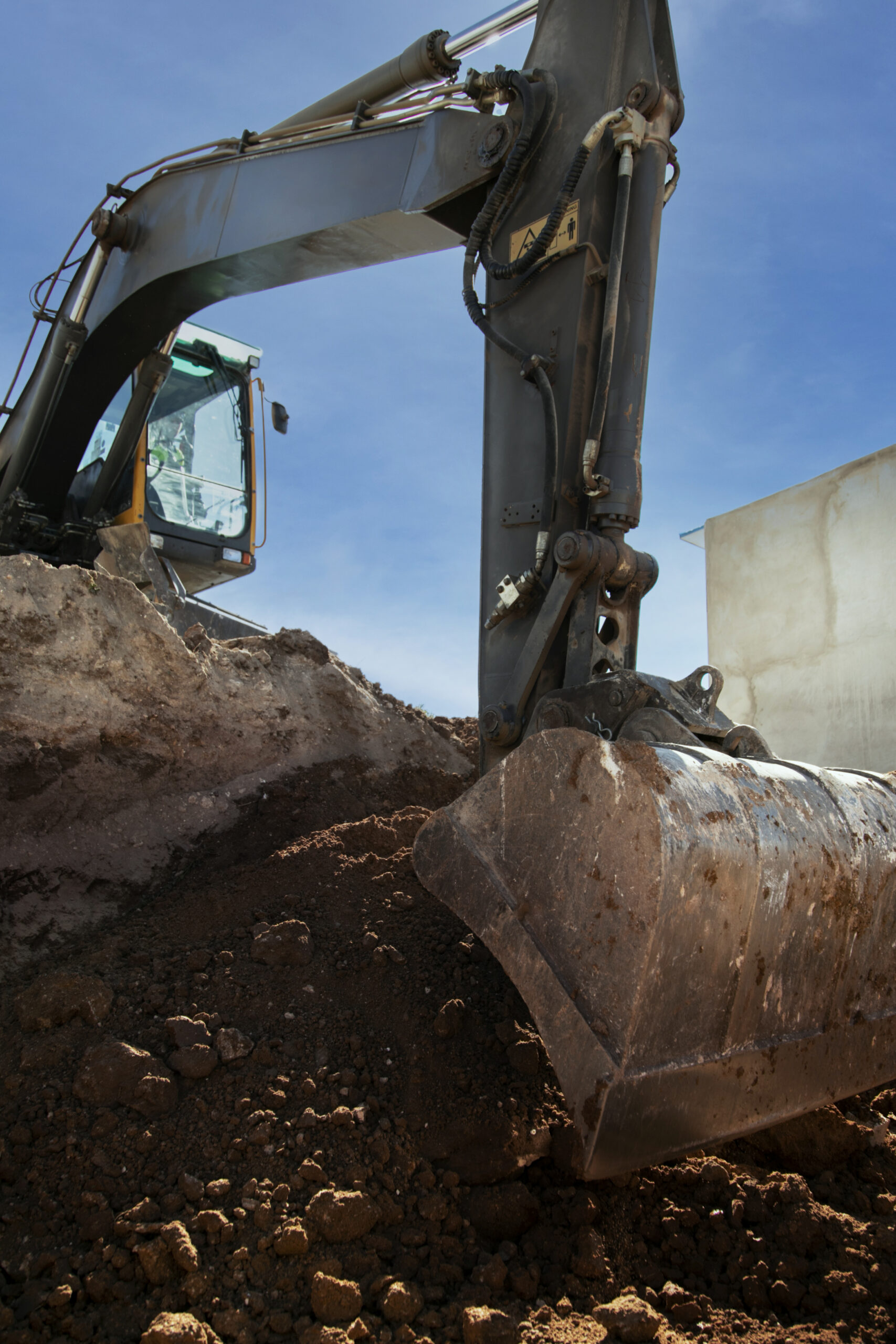 Dirt pile next to an open trench with utility pipes.